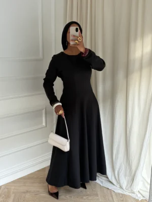 Robe longue noire élégante portée avec des accessoires clairs, style chic et moderne