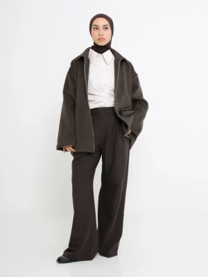 Pantalon à pinces marron porté avec une tenue élégante, style tailleur moderne