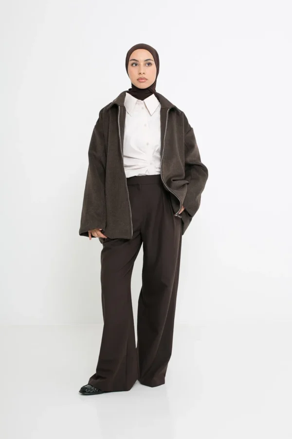 Pantalon à pinces marron porté avec une tenue élégante, style tailleur moderne