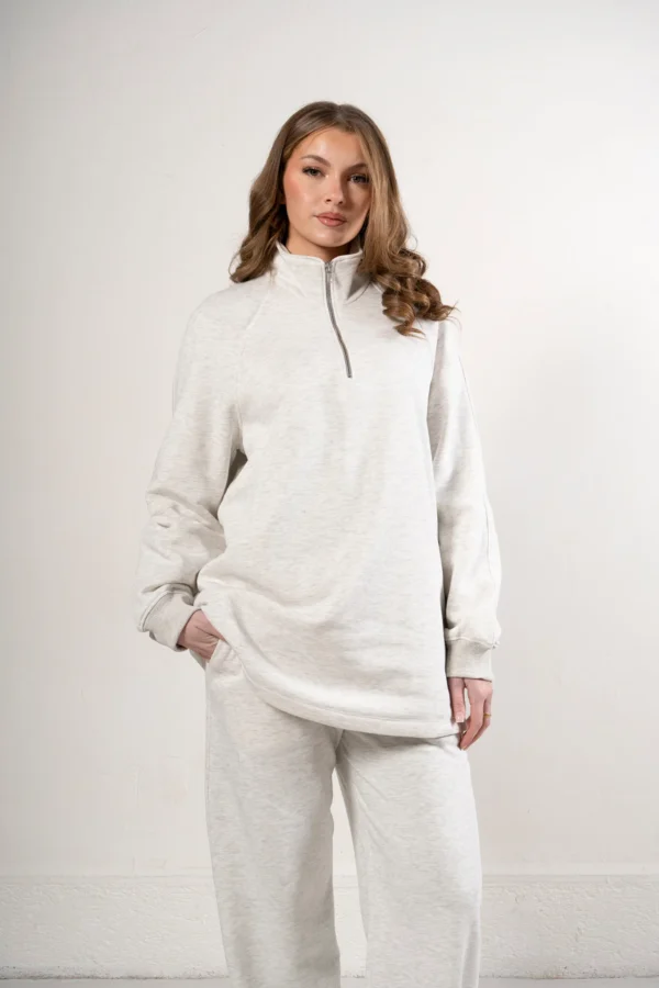 Sweat oversize chiné à col montant zippé porté avec un pantalon assorti