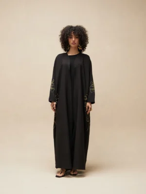 Abaya noire brodée avec motifs floraux verts, coupe longue et élégante
