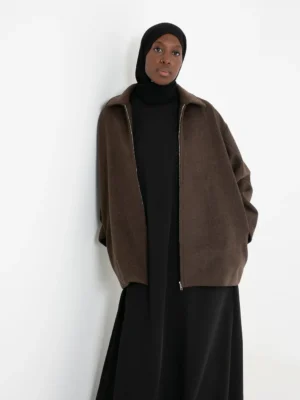 Manteau court marron en laine porté avec une tenue élégante, style raffiné