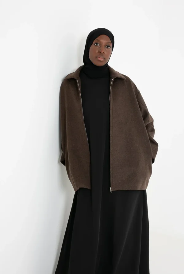 Manteau court marron en laine porté avec une tenue élégante, style raffiné